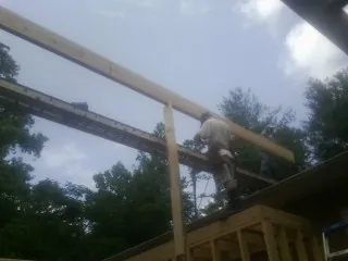 Carpenter setting a ridge beam over a new addition frame — Ice Dam Removal by Roofing Brothers in Galion