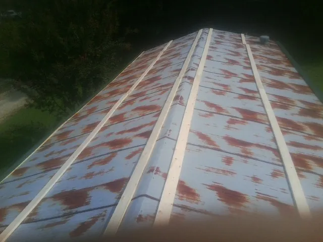 Rusted metal roof panels with new wood purlins before replacement — Storm Damage Roof Repair in Galion by Roofing Brothers