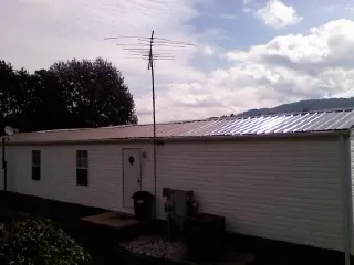 New metal roof on a single wide mobile home with a TV antenna in Galion