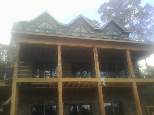 Dormers and porch framing on a large log home under construction — Roof Coating work by our crew in Galion
