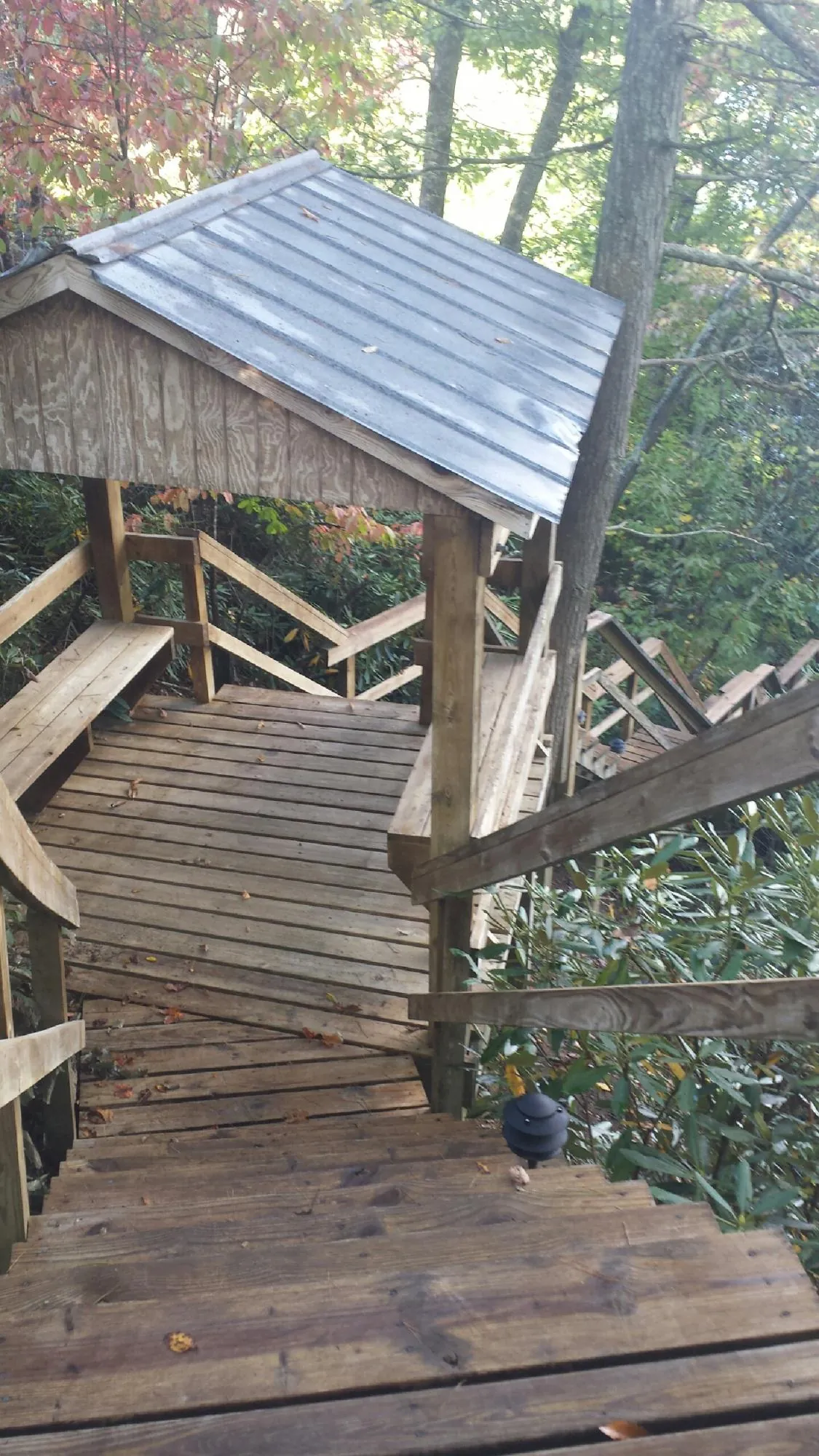 Metal roofed shelter over wooden steps on a wooded walkway — Skylight Repair & Installation work by our crew in Galion